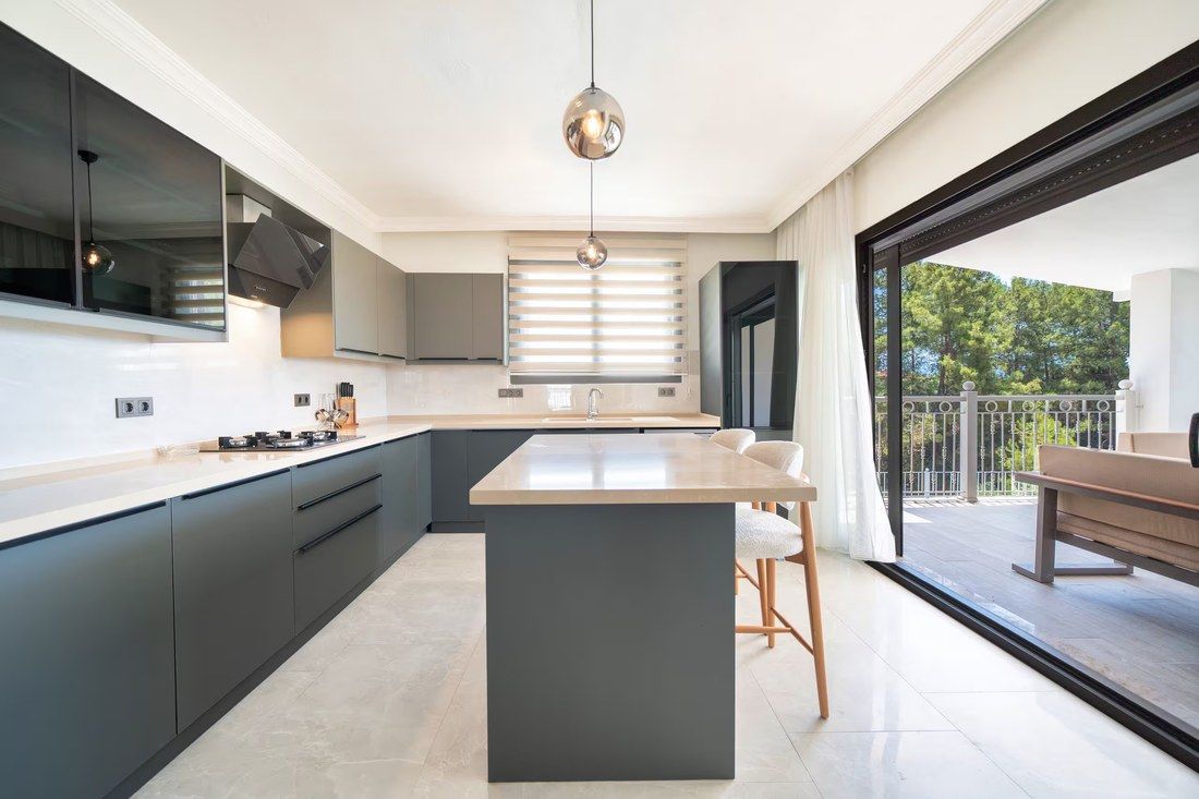 The villa's open kitchen with a breakfast island and doors onto the terrace