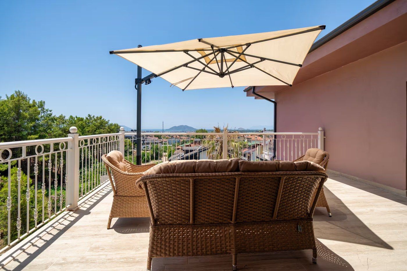 A shaded wicker seating area on the villa terrace, looking out over Fethiye